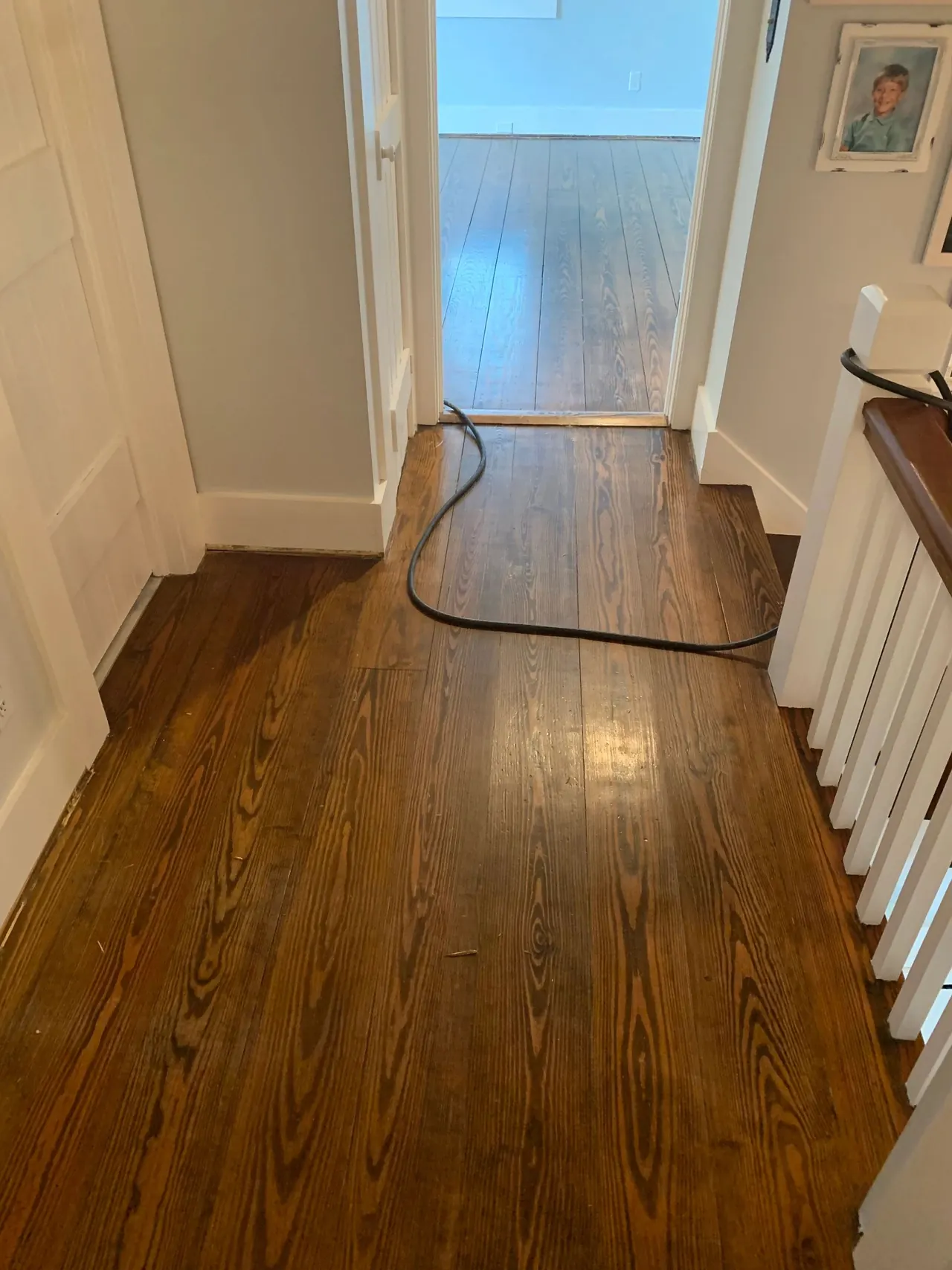 Refinished wide-plank pine hallway floor in a Hampton Roads home