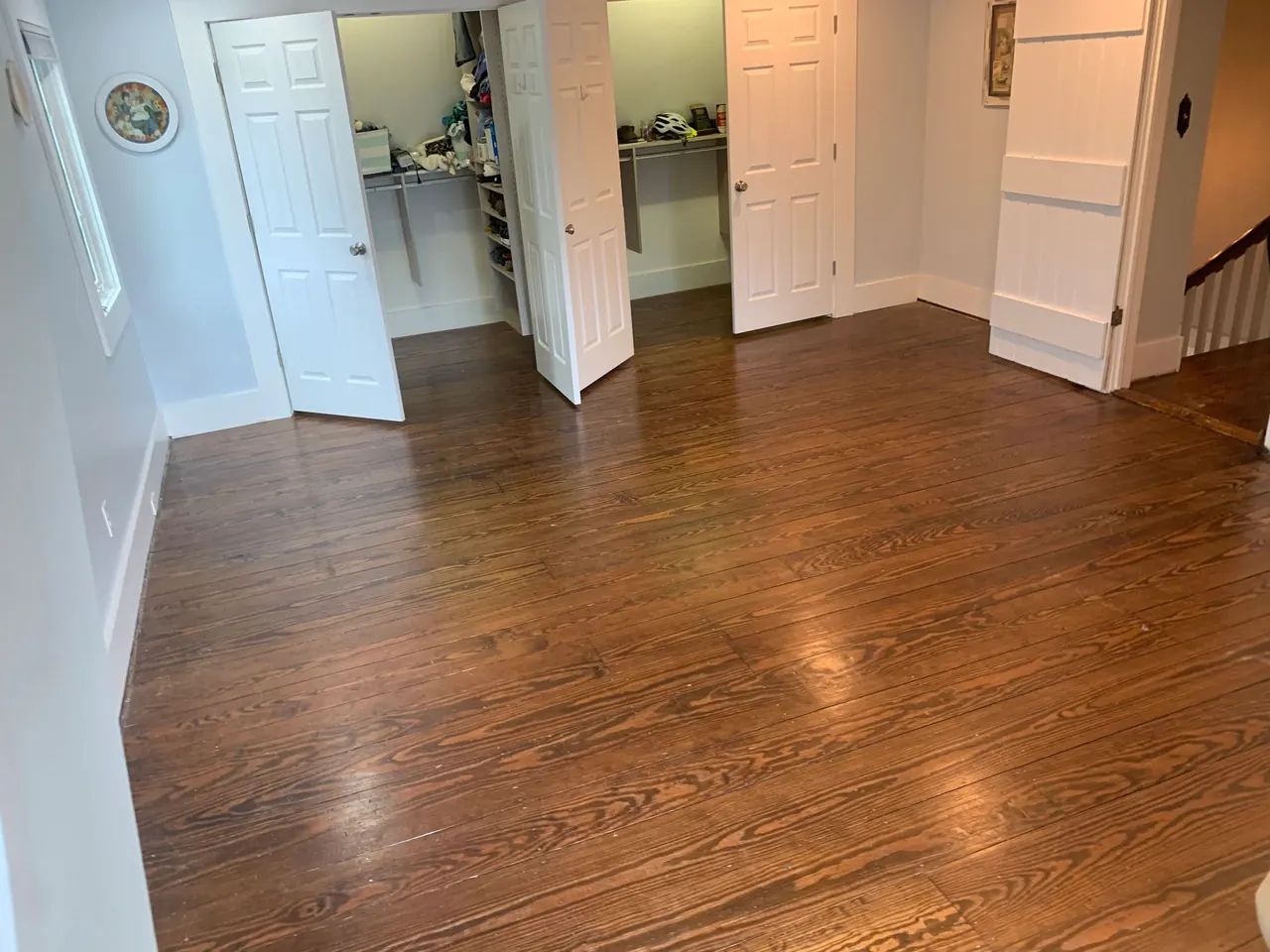 Refinished wide-plank pine bedroom floor with glossy finish